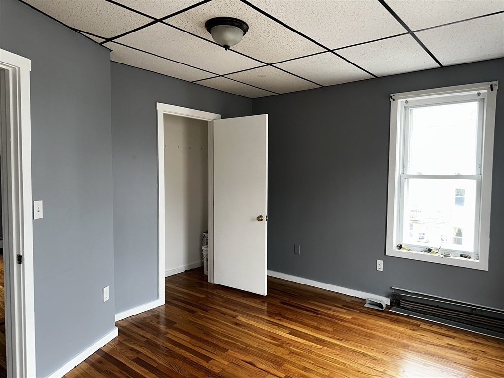 189 5th Street, Unit 2 Fall River, MA 02721 - Photo 6 of 18 a view of an empty room with wooden floor and a window