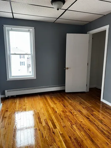 a view of a room with wooden floor and a window