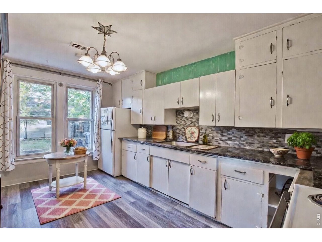 530 Mathews Street Fort Collins, CO 80524 - Photo 11 of 39 a open kitchen with granite countertop a stove a sink dishwasher a dining table and chairs with wooden floor