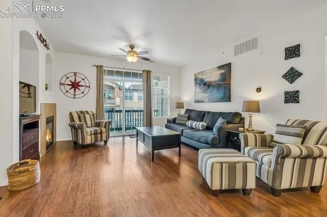 a living room with fireplace furniture and a wooden floor
