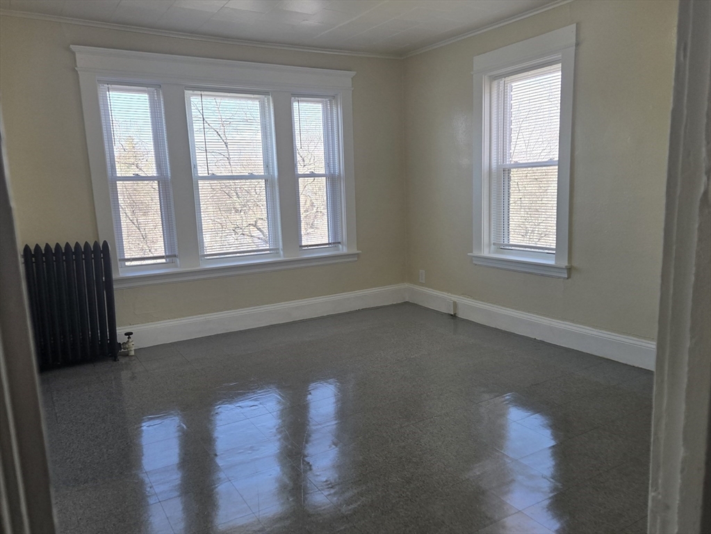 240 Locust Street, Unit 4L Springfield, MA 01108 - Photo 3 of 12 a view of an empty room with wooden floor and a window