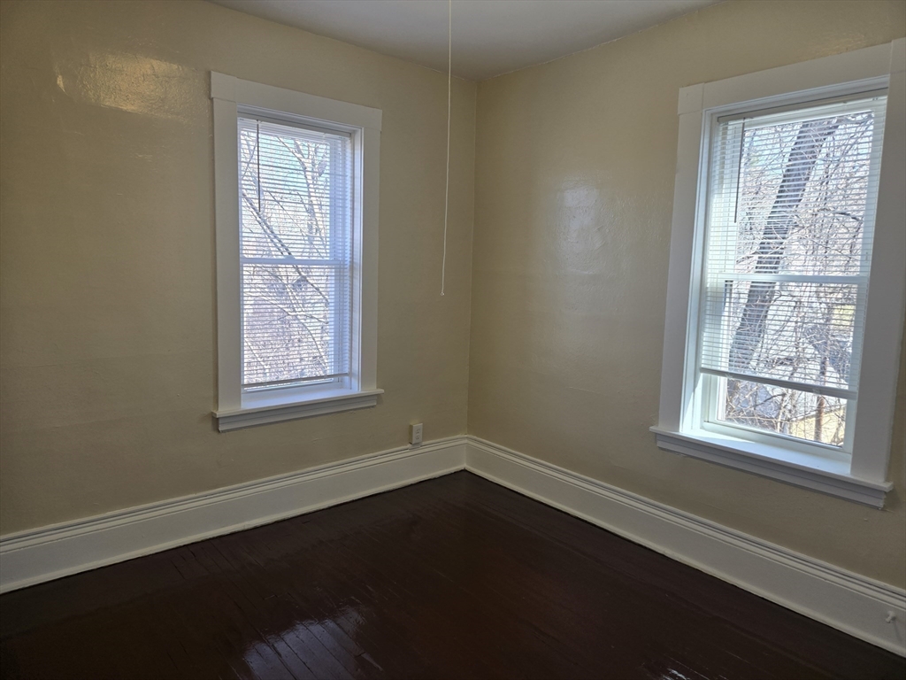 240 Locust Street, Unit 4L Springfield, MA 01108 - Photo 9 of 12 an empty room with wooden floor and windows