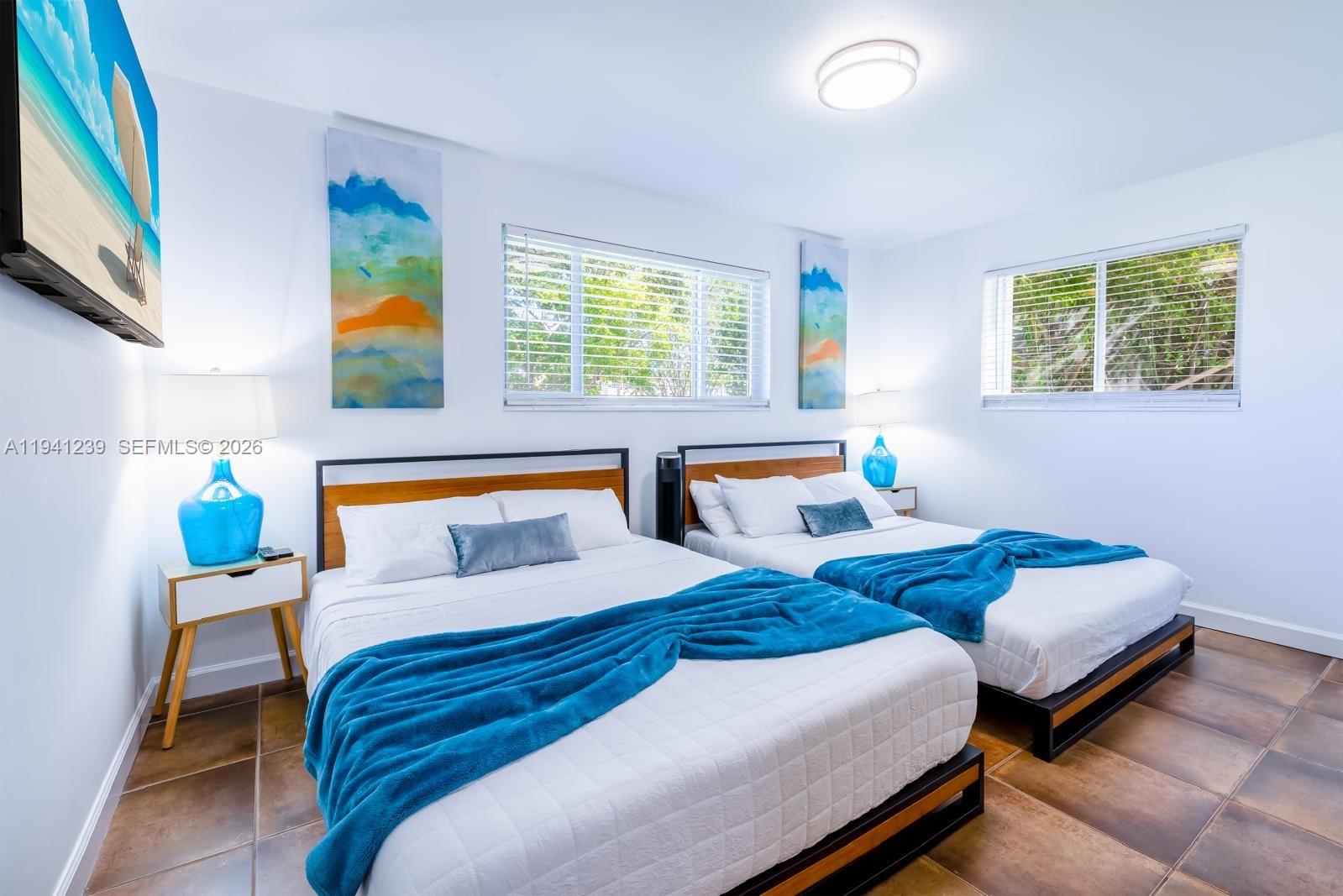 312 North Luna Court Hollywood, FL 33021 - Photo 6 of 60 a bedroom with two beds and a large window