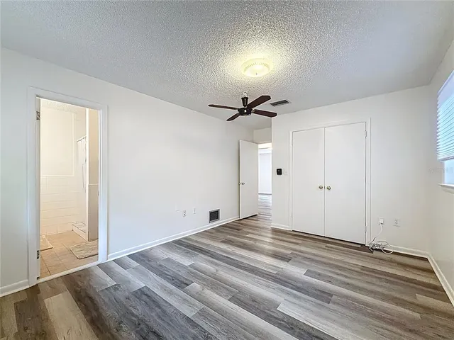 an empty room with a wooden floor and windows