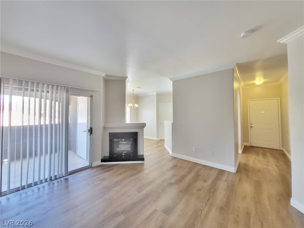 5525 West Flamingo Road, Unit 2040 Las Vegas, NV 89103 - Photo 3 of 15 A well-lit living area features an elegant fireplace and resilient wood flooring, opening to a private balcony.