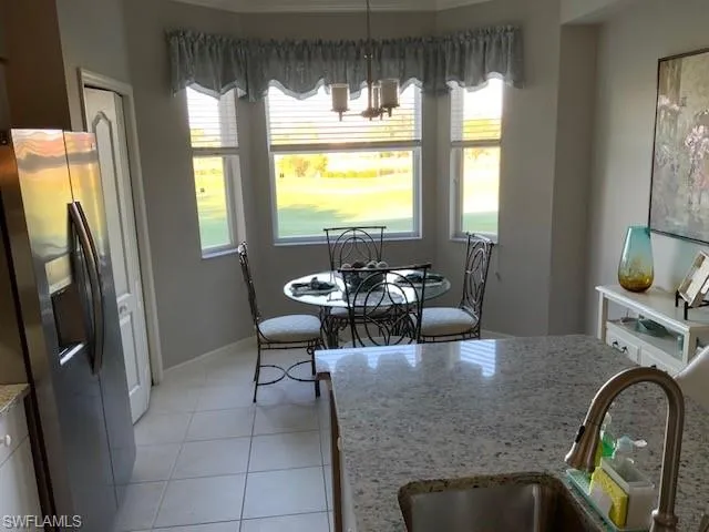 a dining room with furniture a chandelier and wooden floor