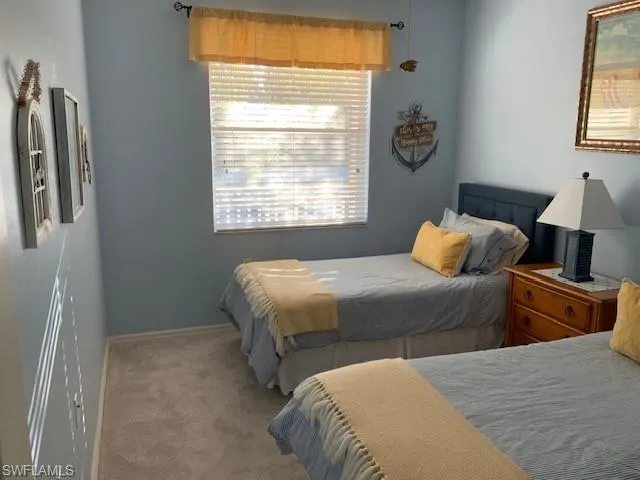 a bedroom with two beds and painting on the wall