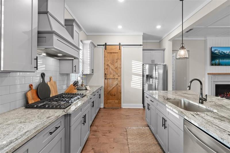 283 London Road Ball Ground, GA 30107 - Photo 24 of 73 a kitchen with stainless steel appliances granite countertop a sink stove and refrigerator