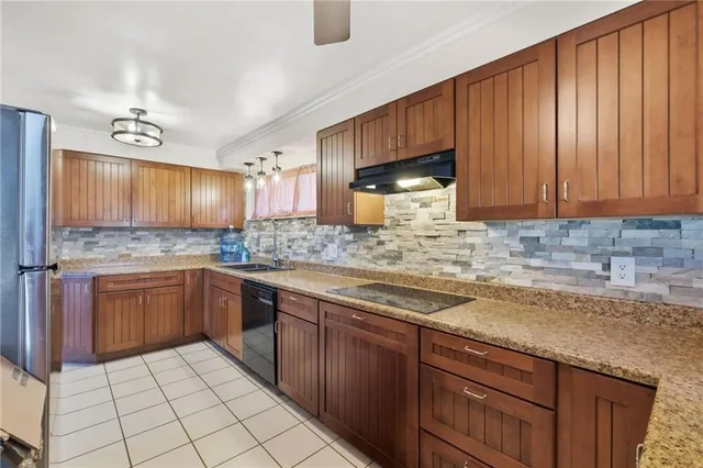 a kitchen with stainless steel appliances granite countertop wooden cabinets a sink and dishwasher