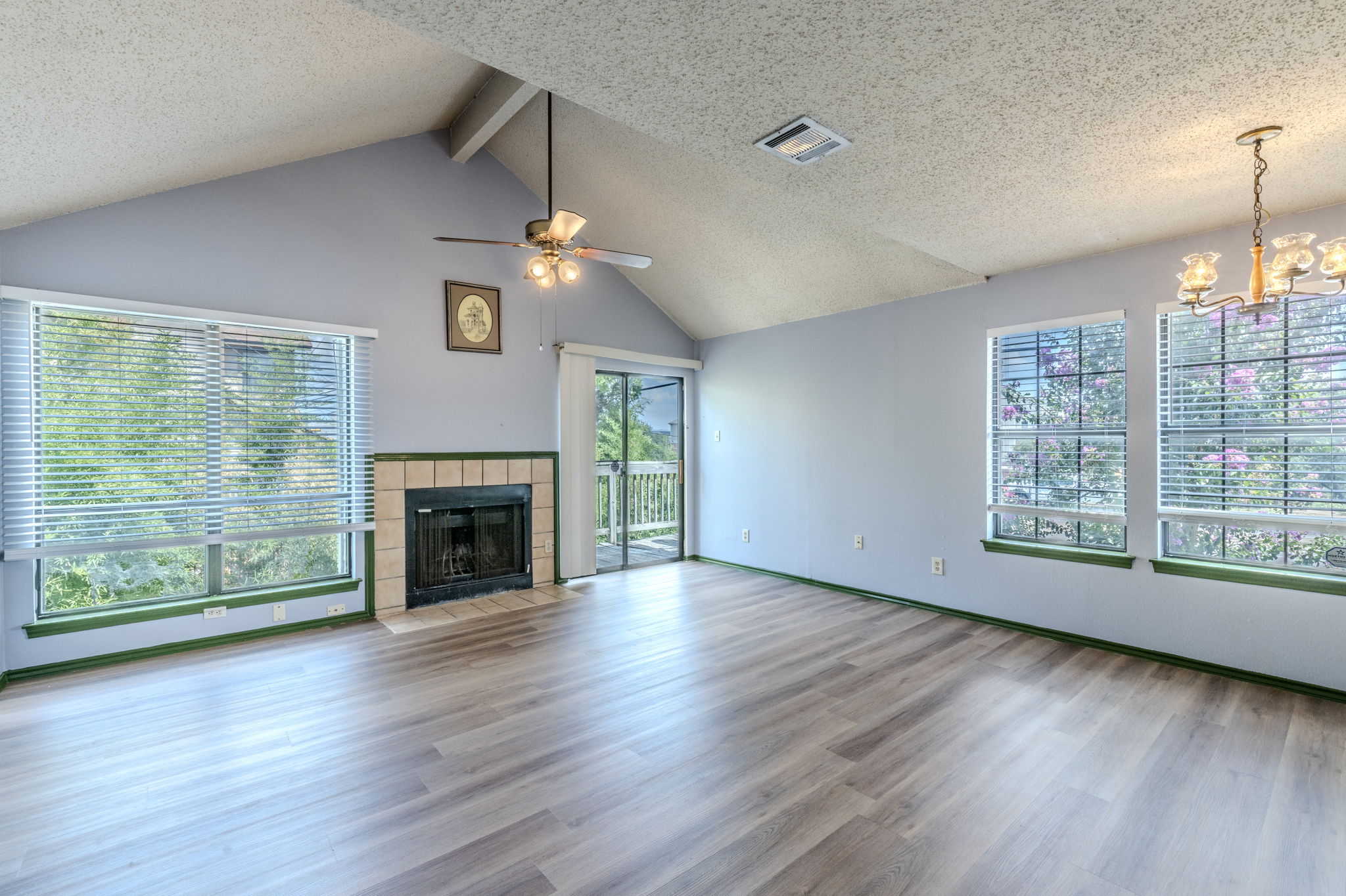 2000 Kenneth Avenue, Unit B Austin, TX 78741 - Photo 2 of 22 A spacious living room features vaulted ceilings, a cozy fireplace, and direct access to outdoor living.