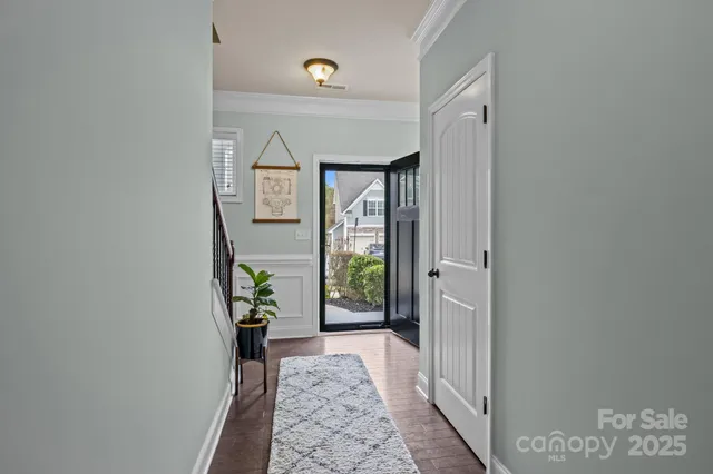 a view of a hallway with wooden floor and a dining room