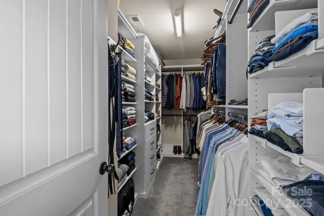 a view of walk in closet with clothes and shoes