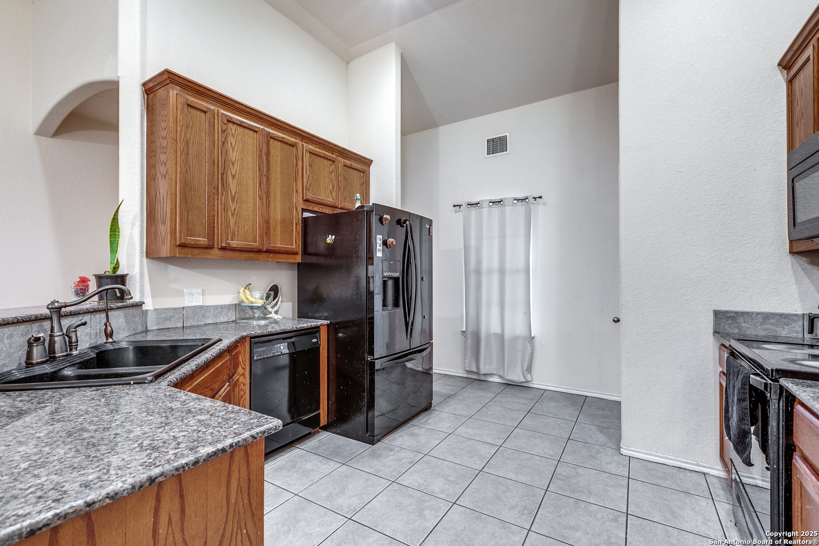 745 Cimarron Square Poteet, TX 78065 - Photo 12 of 33 a kitchen with stainless steel appliances granite countertop a refrigerator stove and sink