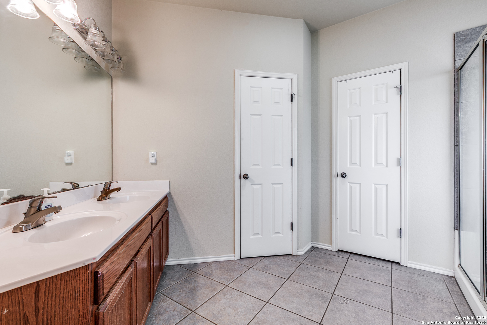 745 Cimarron Square Poteet, TX 78065 - Photo 17 of 33 a bathroom with a sink vanity and a mirror