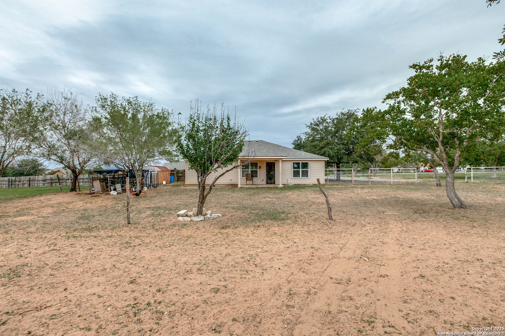 745 Cimarron Square Poteet, TX 78065 - Photo 2 of 33 a white house that has a tree in front of it