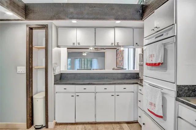 a kitchen with granite countertop a white cabinets and refrigerator
