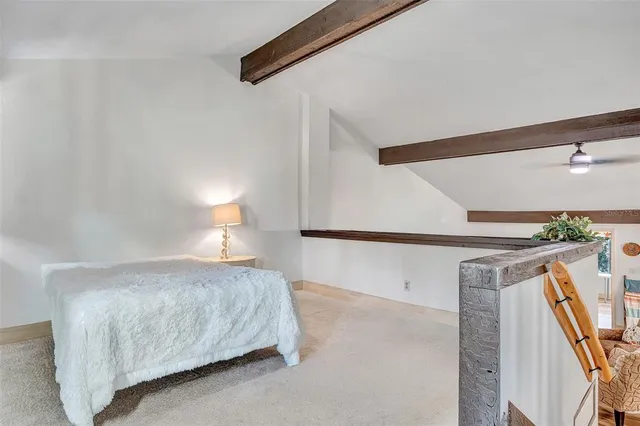 a bedroom with a bed and a potted plant on the dresser