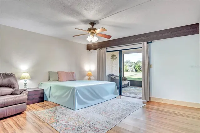 a bedroom with a large bed chandelier and a window