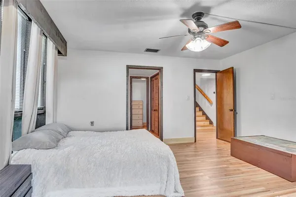 a bedroom with a bed and a large mirror with wooden floor