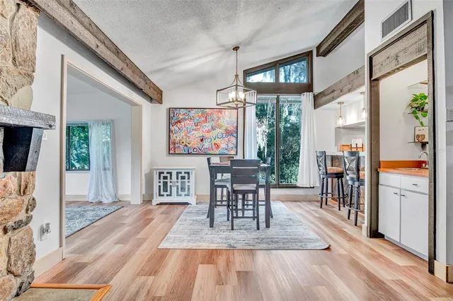 a view of a dining room with furniture a chandelier and wooden floor