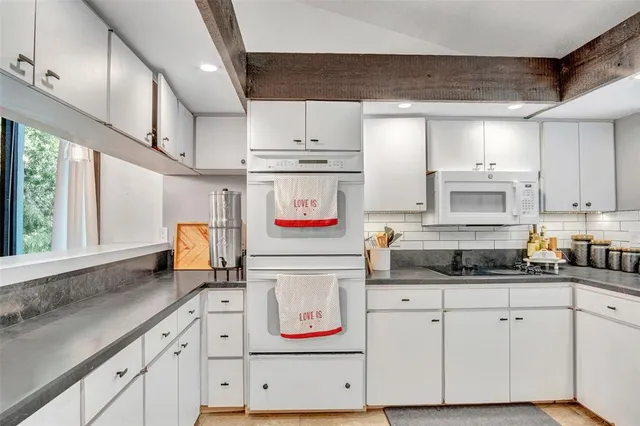 a kitchen with stainless steel appliances white cabinets and a window