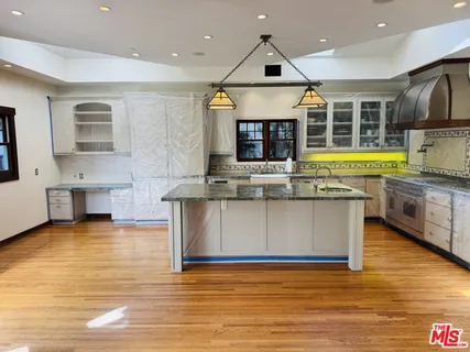 a view of a kitchen with stainless steel appliances granite countertop a stove a sink and a microwave