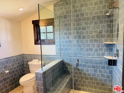 a bathroom with a toilet a window and tub