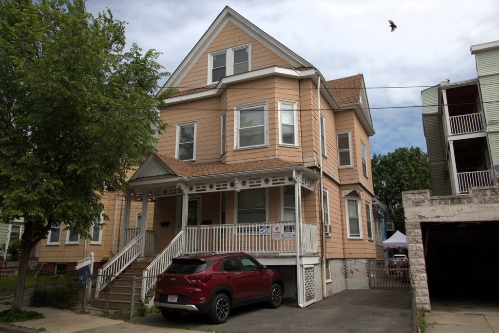 a car parked in front of a white house