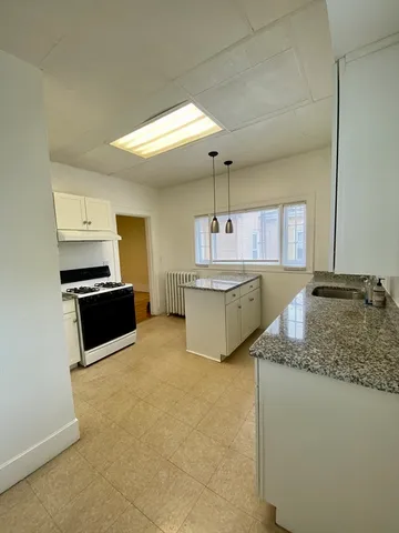 a kitchen with stainless steel appliances granite countertop a sink and a stove top oven