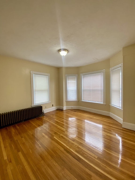 7 Stickney Avenue Somerville, MA 02145 - Photo 8 of 16 a view of an empty room with wooden floor and a window