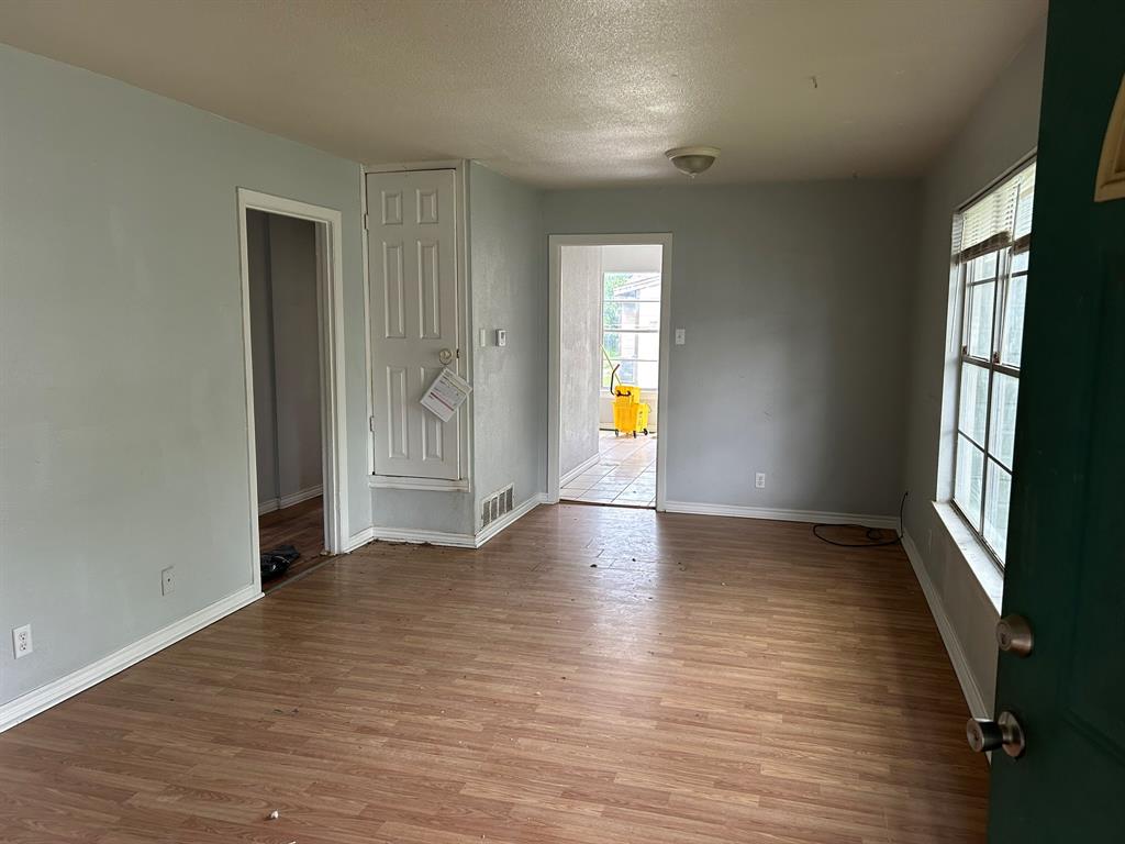 6 Pershing Drive Denison, TX 75020 - Photo 4 of 13 an empty room with wooden floor and a window