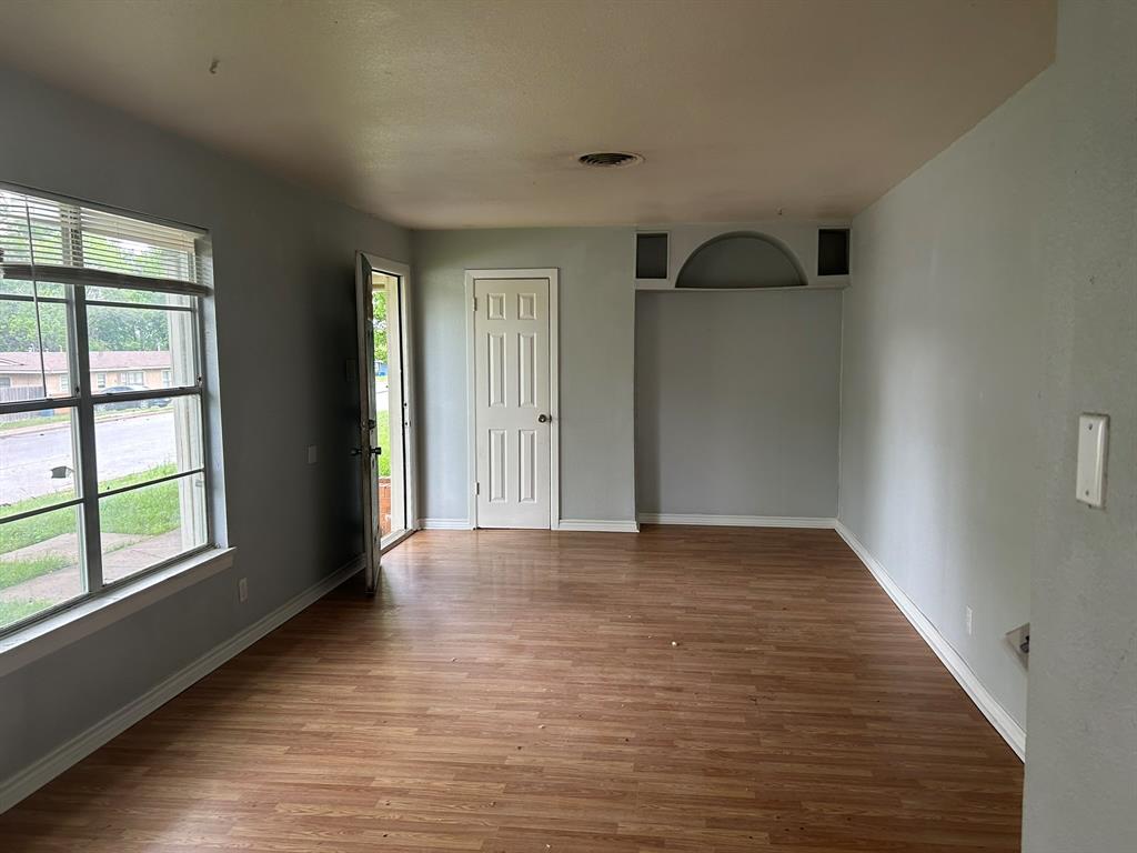 6 Pershing Drive Denison, TX 75020 - Photo 5 of 13 a view of an empty room with window and wooden floor