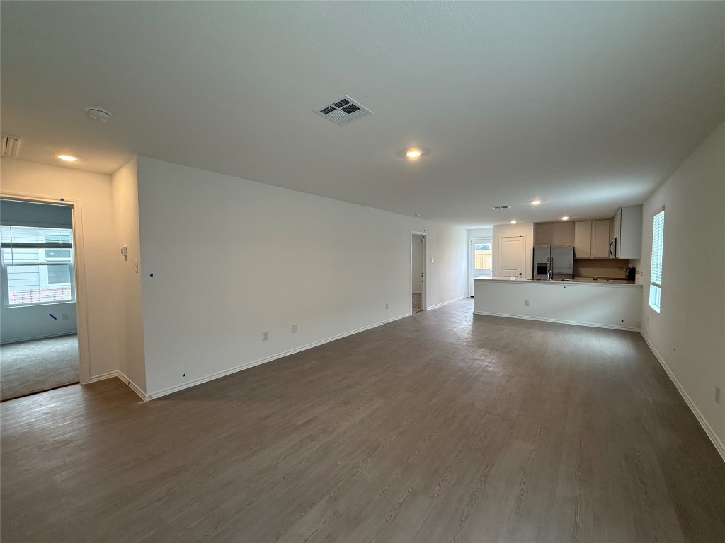 120 Cattle Queen Road Jarrell, TX 76537 - Photo 6 of 9 a view of empty room with wooden floor and windows