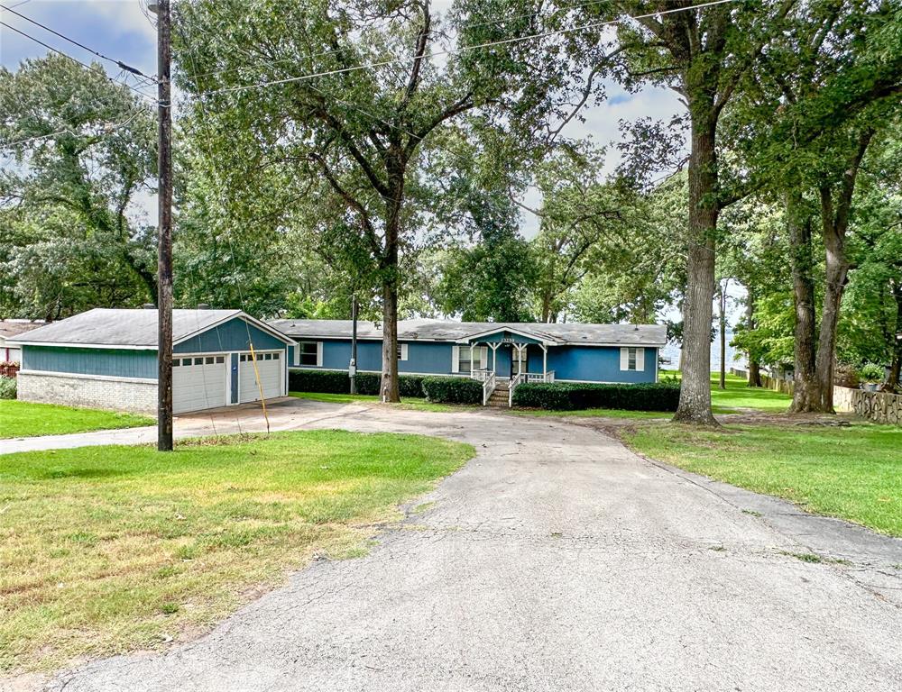 a front view of a house with a garden and trees