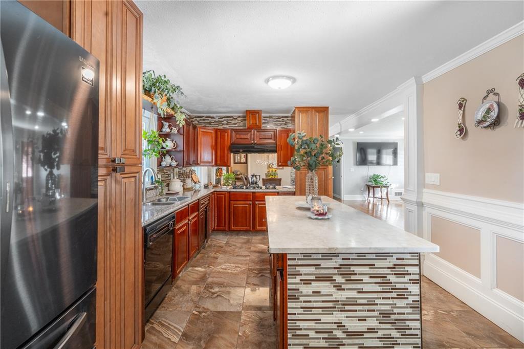 4983 Arcado Road Southwest Lilburn, GA 30047 - Photo 13 of 33 a kitchen with stainless steel appliances kitchen island granite countertop a refrigerator a sink and a stove