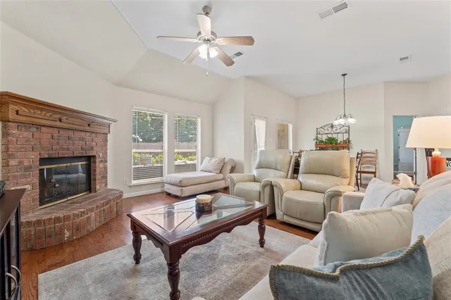 a living room with furniture a fireplace and a chandelier