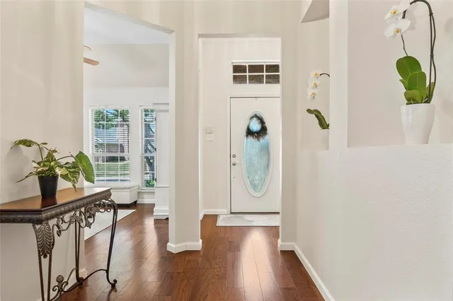 a view of a hallway with wooden floor and windows