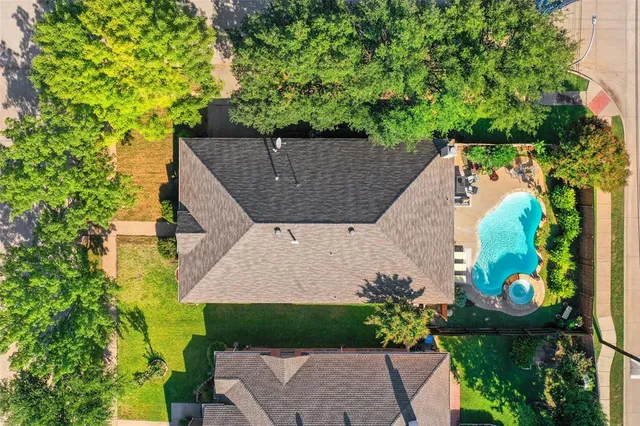 an aerial view of a house with a yard and black swimming pool