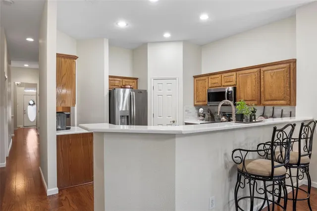 a kitchen with stainless steel appliances granite countertop a sink and a refrigerator