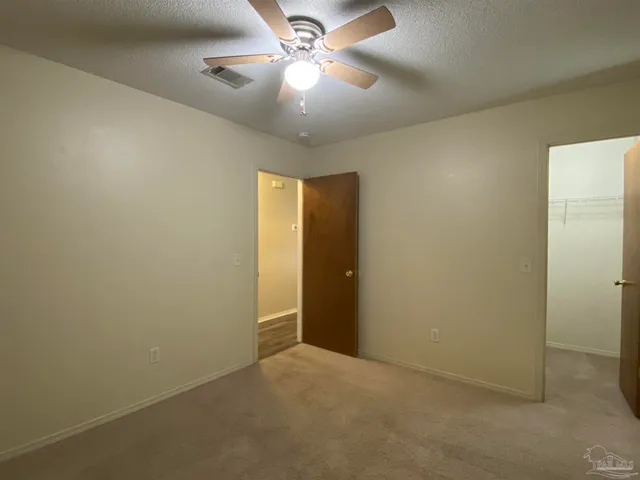 an empty room with a chandelier fan and a chandelier fan