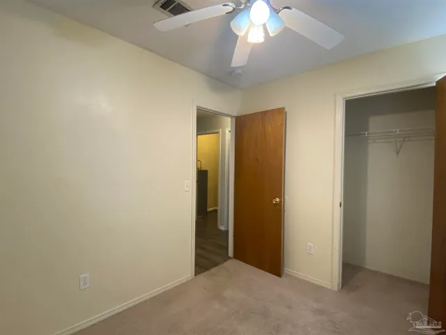 a view of an empty room with a ceiling fan