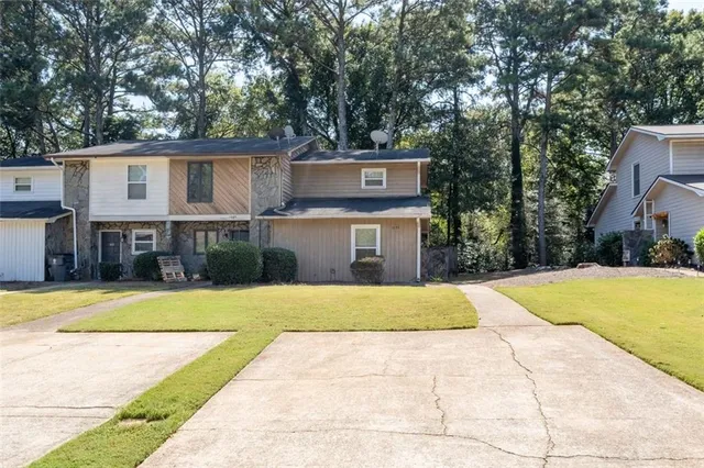 a front view of a house with a yard and trees