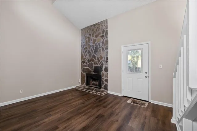 a view of a livingroom with wooden floor and a fireplace