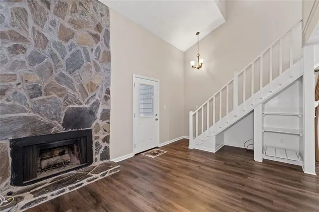 a view of a livingroom with wooden floor and a fireplace