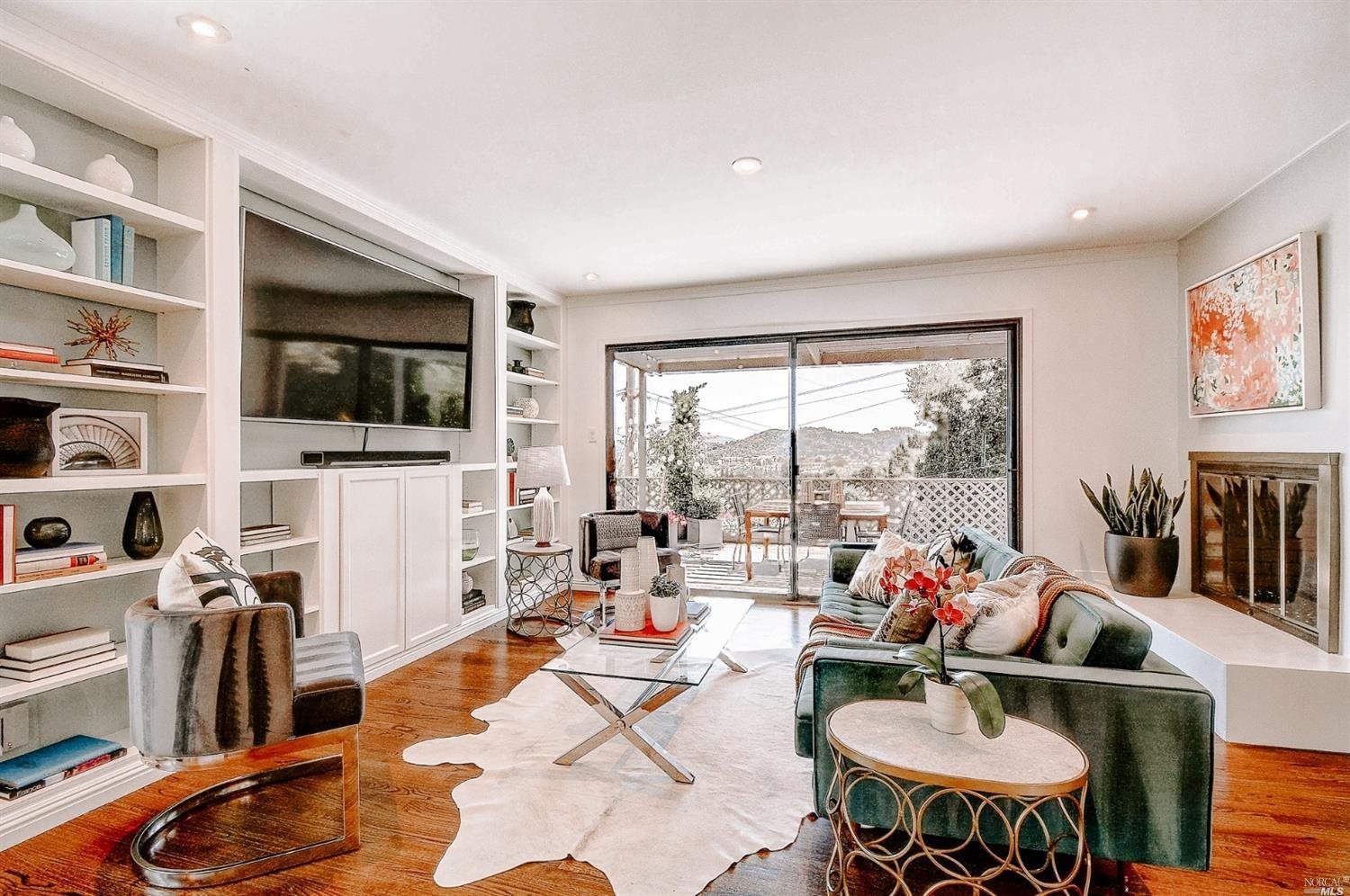 a living room with furniture a flat screen tv and a dining table with wooden floor