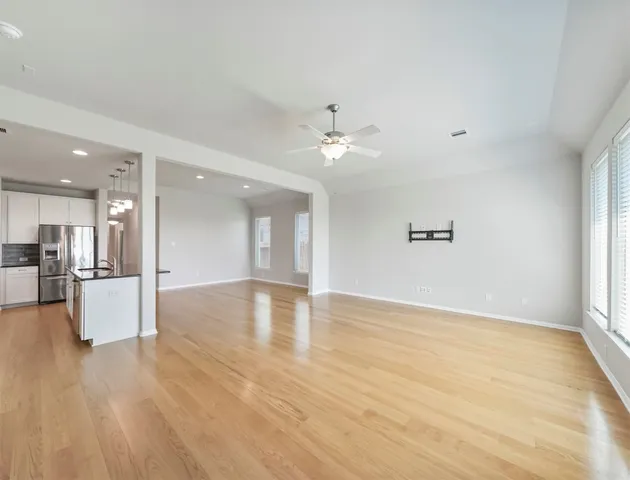 a view of an empty room and kitchen view