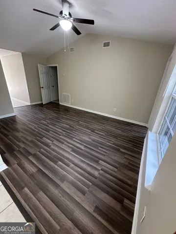 a view of empty room with wooden floor
