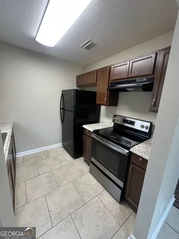 a kitchen with a stove and a refrigerator