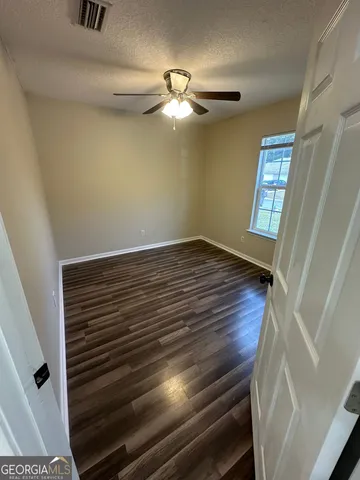 a view of room with window and wooden floor