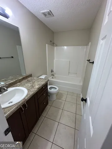 a bathroom with a granite countertop sink a toilet and a mirror